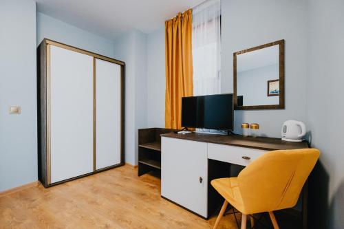 um quarto com uma secretária com um espelho e uma cadeira em Miletia Suites em Sozopol