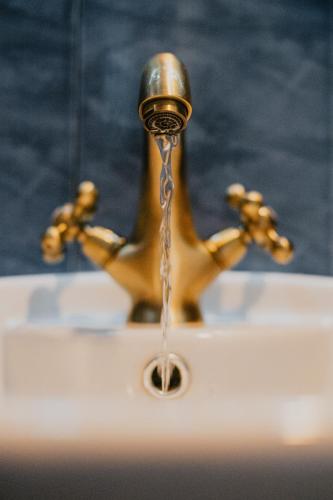 a faucet with water coming out of it at Miletia Suites in Sozopol