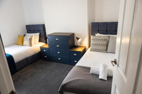 um quarto com 2 camas e uma cómoda azul em Fred's Place em Plymouth