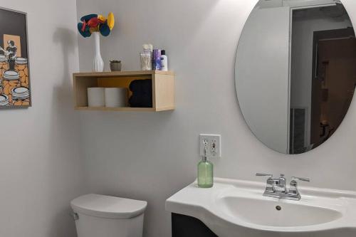 uma casa de banho com um lavatório branco e um espelho. em Retro suite with separate office walking- distance to downtown Silver Spring! em Silver Spring