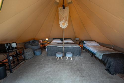 um quarto com duas camas numa tenda em SolinaGlamp em Polańczyk