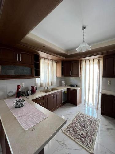 a kitchen with wooden cabinets and a counter top at Ornela's Home in Yiánnidhes