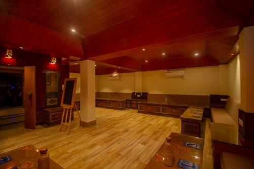 an empty room with a stage in a room with wooden floors at Amritara Hidden Land, Gangtok - 900 mts from MG Marg in Gangtok