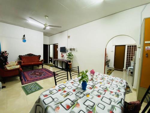 a living room with a table in the middle of a room at Homestay Ummi Gong Badak in Kuala Terengganu