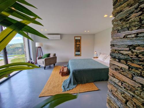 a bedroom with a bed and a stone wall at Casas de Gondarem by the Douro Valley in Raiva