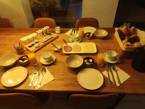 een houten tafel met witte borden en keukengerei erop bij B&B Emmylou in Gouvy