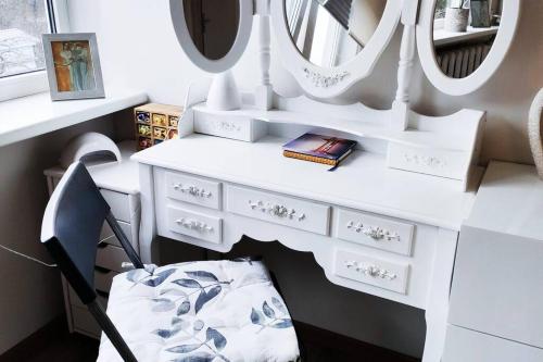 a white dressing table with a chair and mirrors at Fantastic 170m2 Villa with a big garden in Pärnu