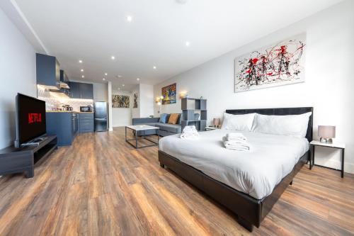 a bedroom with a large bed and a living room at 2 - West London Brand New Loft in London
