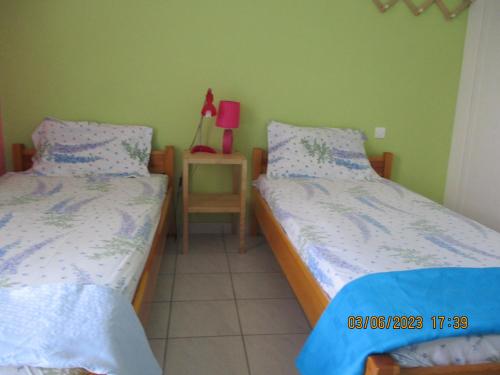 a bedroom with two beds and a table with a lamp at Anna's Sweet Home Akrata in Paralía Akrátas