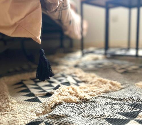 une personne tenant un objet noir sur un lit dans l'établissement L'Oasis Cosy, à Villeurbanne