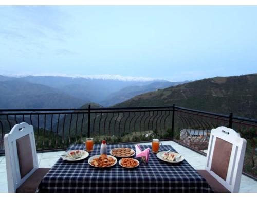 una mesa con platos de comida en la parte superior de un balcón en Shining Star Resort, Khajjiar, en Khajjiar 