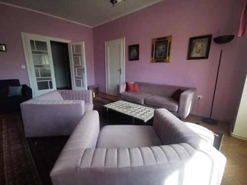 a living room with white furniture and pink walls at APARTAMENT MARIO bezpłatny parking in Bielsko-Biala