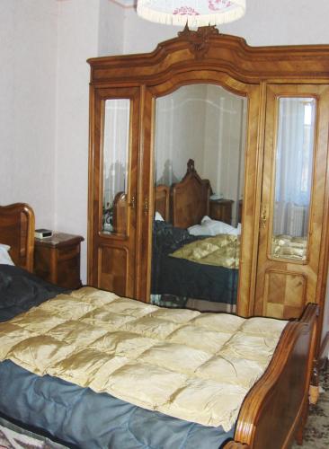ein Schlafzimmer mit einem Bett und einem großen Spiegel in der Unterkunft Brasserie de l'Eichel-t-Ale in Voellerdingen