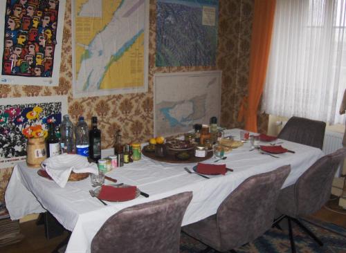 einen Tisch mit einer weißen Tischdecke und Stühlen mit Essen drauf in der Unterkunft Brasserie de l'Eichel-t-Ale in Voellerdingen