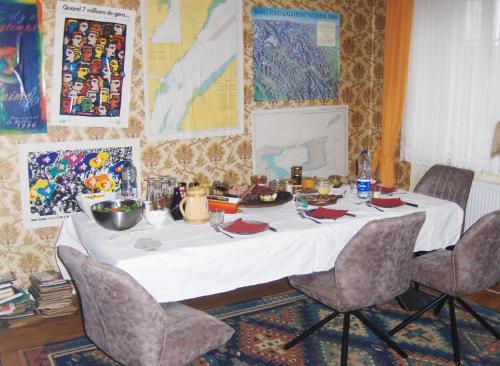 einen Tisch mit einem weißen Tischtuch und Stühlen in der Unterkunft Brasserie de l'Eichel-t-Ale in Voellerdingen