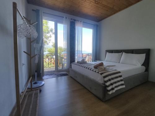 een slaapkamer met een bed en een groot raam bij ROLEO Guest House in Lin