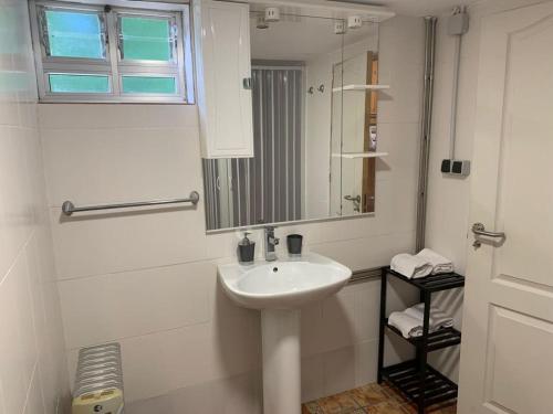 uma casa de banho branca com um lavatório e um espelho em Albergue Naturmaz em Mazaricos