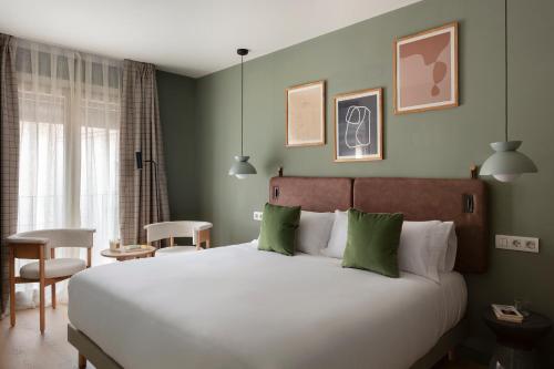 TOC Hotel Las Ramblas في برشلونة: غرفة نوم بسرير ابيض كبير بجدران خضراء