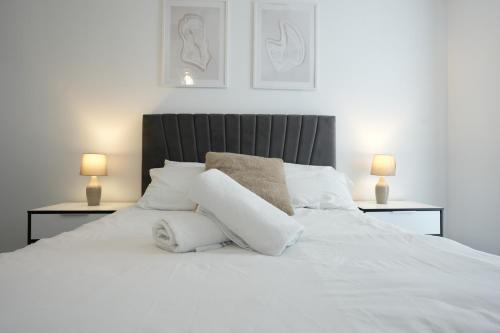 1 cama blanca con almohadas blancas y 2 lámparas en Cosy 1 bed - Heart of Birmingham, en Birmingham