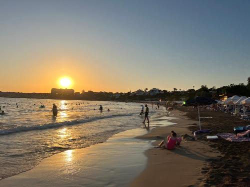 a group of people on the beach at sunset at Villa Marina Sea-View Private Pool in Peyia