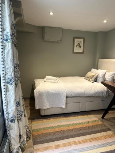 a bedroom with a bed with white sheets at Unique Clifton apartment on historic crescent in Bristol