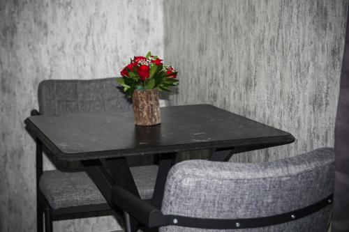 uma mesa com duas cadeiras e um vaso com flores em The Hera Bostancı em Istambul