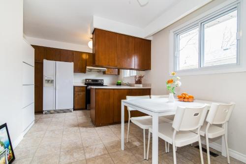 cocina con mesa blanca y electrodomésticos blancos en spacious and bright house, en Toronto