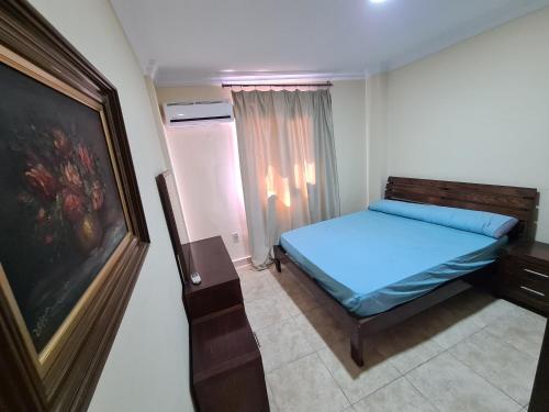 a small bedroom with a blue bed and a window at Luxury Chalet With Roof at Nice 4 North coast kilo 75 نيس ٤ in Dawwār Abū Duray‘ah ‘Abd al Karīm