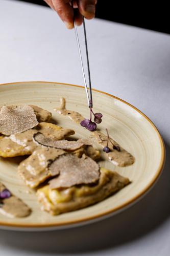 a plate of food with a person holding a knife at Tenuta di Artimino member of Meliá Collection Wine Resort in Artimino