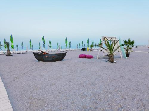 a beach with a boat and a tent on the sand at Vila Plaja Azur in Eforie Nord