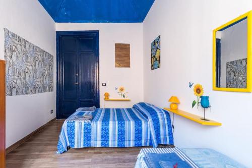 a bedroom with a bed and a blue ceiling at Stanze al Capo in Palermo