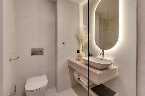 a bathroom with a sink and a toilet and a mirror at GRANO HOTEL Solmarina in Wiślinka