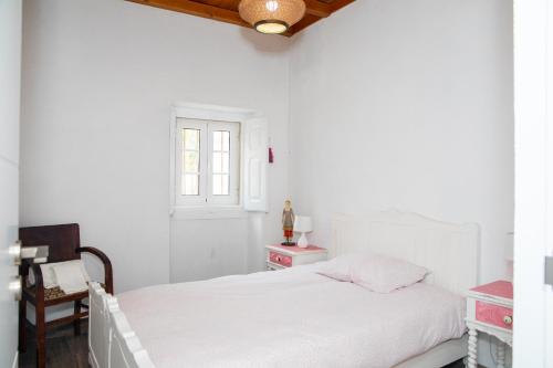 a white bedroom with a bed and a window at Quinta Santo António in Pereiro da Palhacana