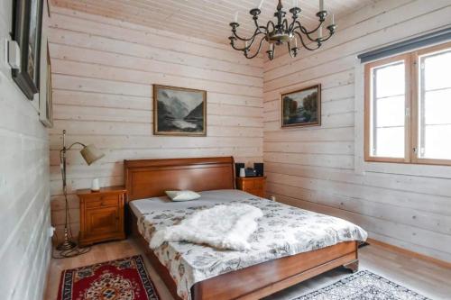 sypialnia z łóżkiem i żyrandolem w obiekcie Villa Classic w mieście Ähtäri