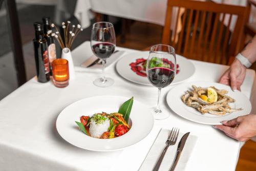 una mesa con platos de comida y copas de vino en Guadalpin Suites, en Marbella