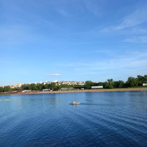 a person in a boat on a large body of water at RIVIJERA LAKES Ada Studio in Belgrade