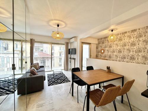 un salon avec une table et un canapé dans l'établissement ApartHotel Riviera - Nice Carré d'Or - Large studio AC Terrasse - Très calme - BALCON BERLIOZ 2, à Nice