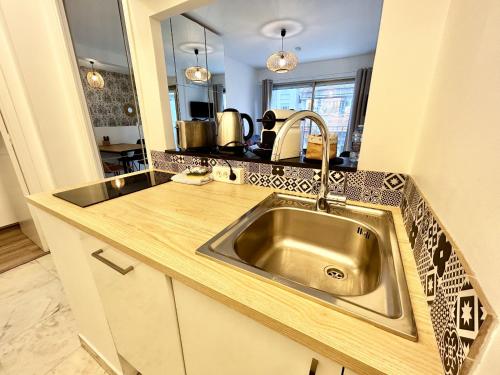 une cuisine avec un évier et un plan de travail dans l'établissement ApartHotel Riviera - Nice Carré d'Or - Large studio AC Terrasse - Très calme - BALCON BERLIOZ 2, à Nice