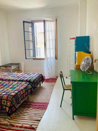 une chambre avec un lit, un bureau et une fenêtre dans l'établissement Les Cagettes en Ville, à Perpignan