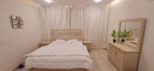 a small bedroom with a bed and a mirror at شقة فندقية مستقلة in Daḩārīz