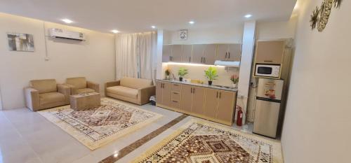 a kitchen with two chairs and a refrigerator at شقة فندقية مستقلة in Daḩārīz