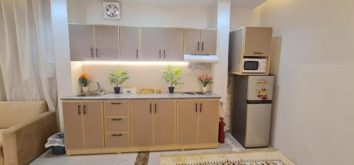 a small kitchen with a refrigerator and a sink at شقة فندقية مستقلة in Daḩārīz