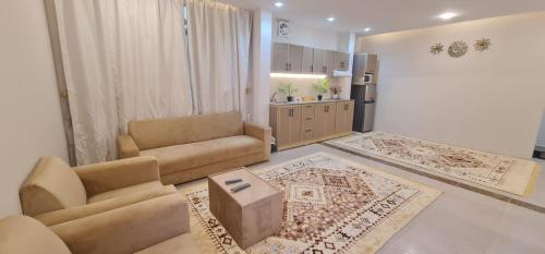 a living room with two couches and a kitchen at شقة فندقية مستقلة in Daḩārīz