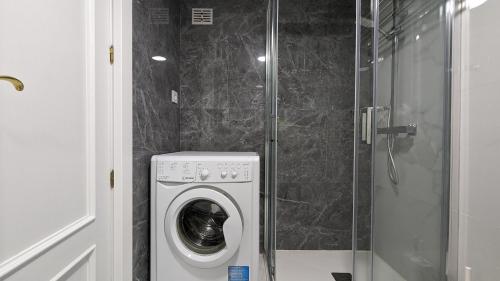 a washing machine in a bathroom with a shower at DON MIGUEL sea view apartment in Benidorm
