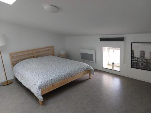 1 dormitorio con cama y ventana en Studio mezzanine tout confort en Corny-sur-Moselle