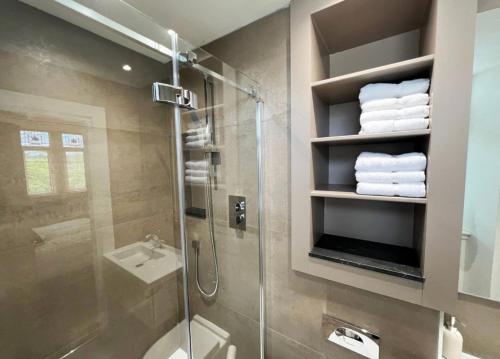 a bathroom with a shower and a toilet and a sink at Carlibar Villa in Barrhead