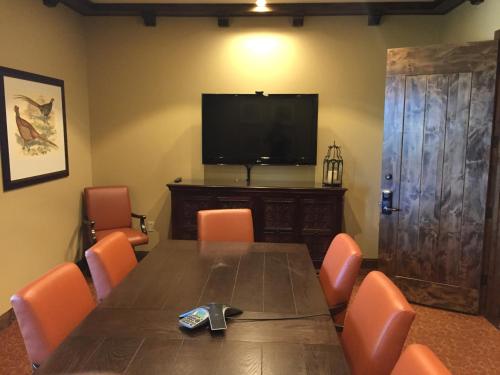 a conference room with a wooden table and a television at Ponte Vineyard Inn in Temecula
