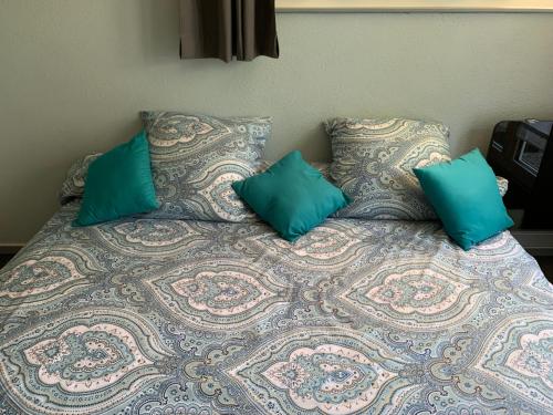 a bed with turquoise pillows on top of it at Le lotus zen in Froideville