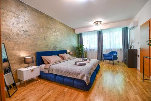 a bedroom with a large bed with a blue headboard at BNF Lounge in Varaždin