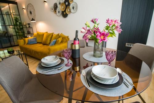 a dining room table with a wine bottle and flowers on it at BNF Lounge in Varaždin